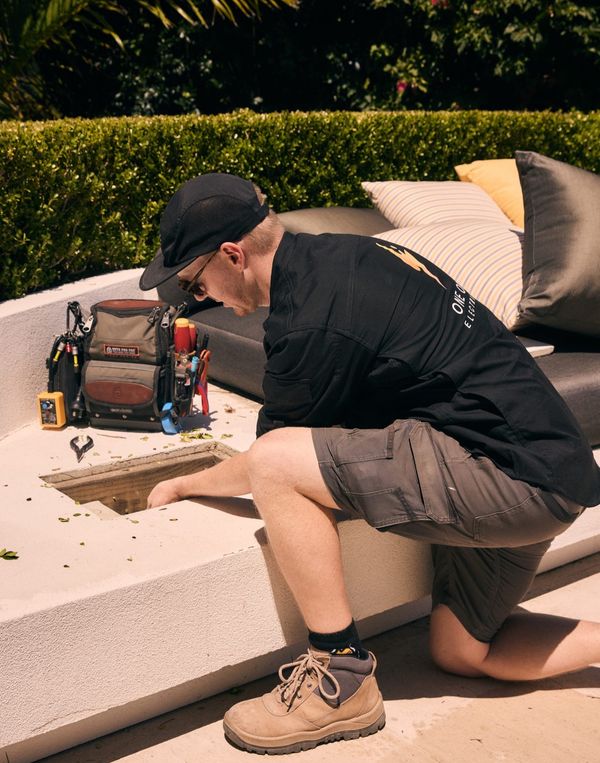 One Out Electrical electrician servicing an outdoor electrical junction point in a residential garden