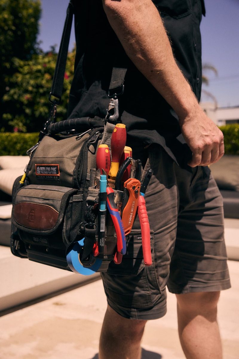 One Out Electrical electrician on a job carrying a fully stocked professional tool bag