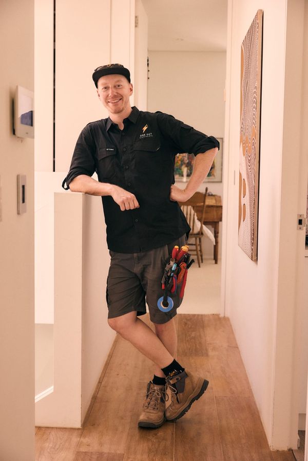 Smiling One Out Electrical electrician in a Hobart home hallway after completing a smart home job