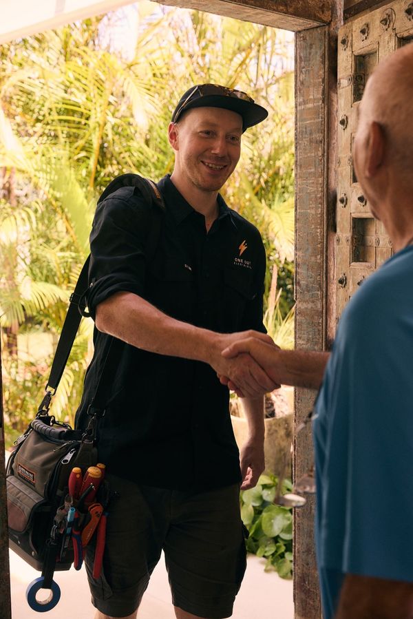 One Out Electrical electrician greeting a customer with a handshake on arrival at their front door