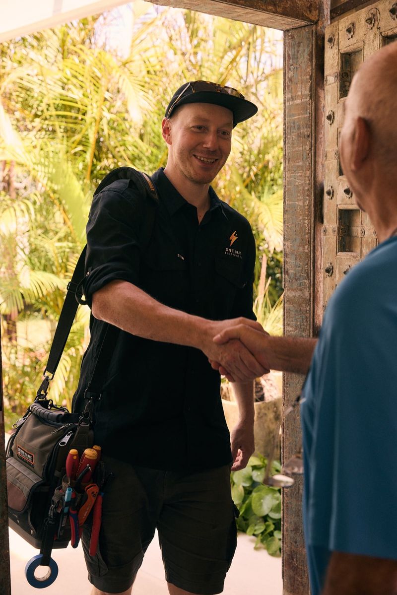 One Out Electrical electrician greeting a customer with a handshake on arrival at their front door