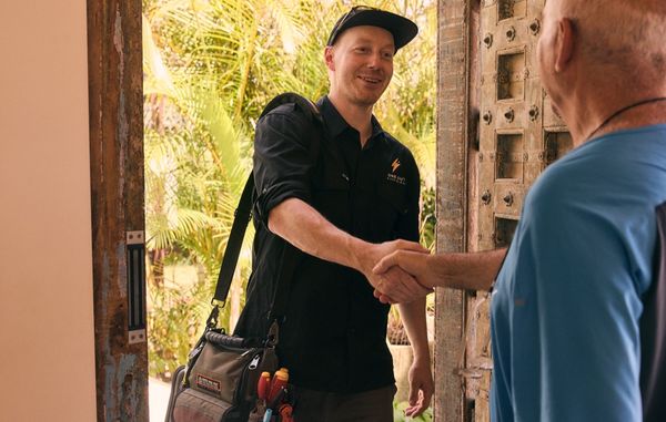 One Out Electrical electrician arriving and meeting a customer at the door of a Hobart property