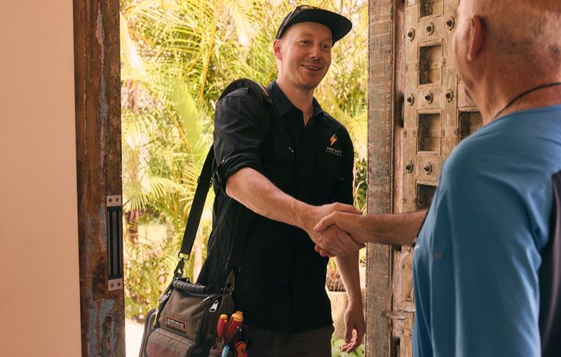 One Out Electrical electrician arriving and meeting a customer at the door of a Hobart property
