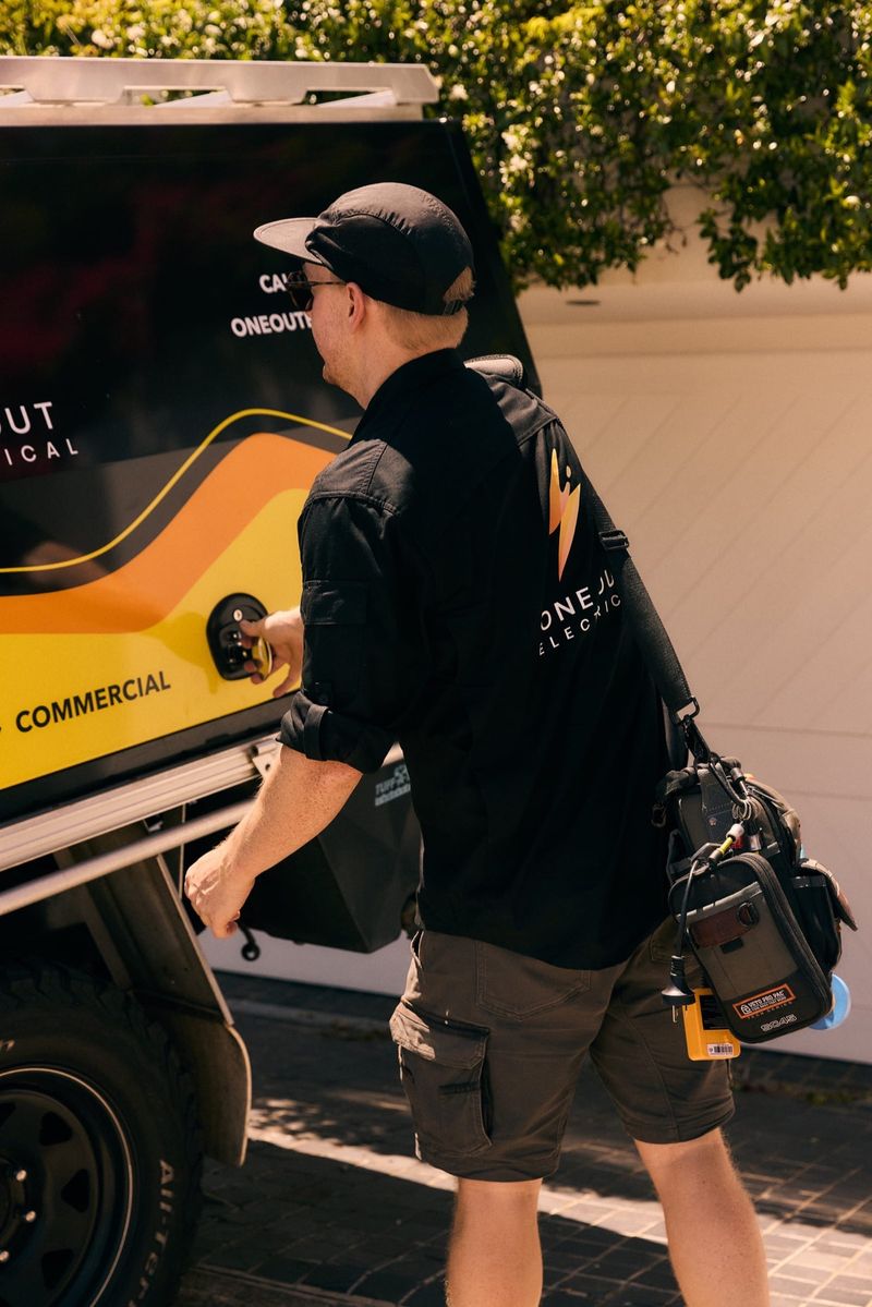 One Out Electrical electrician accessing equipment from the branded service vehicle tray