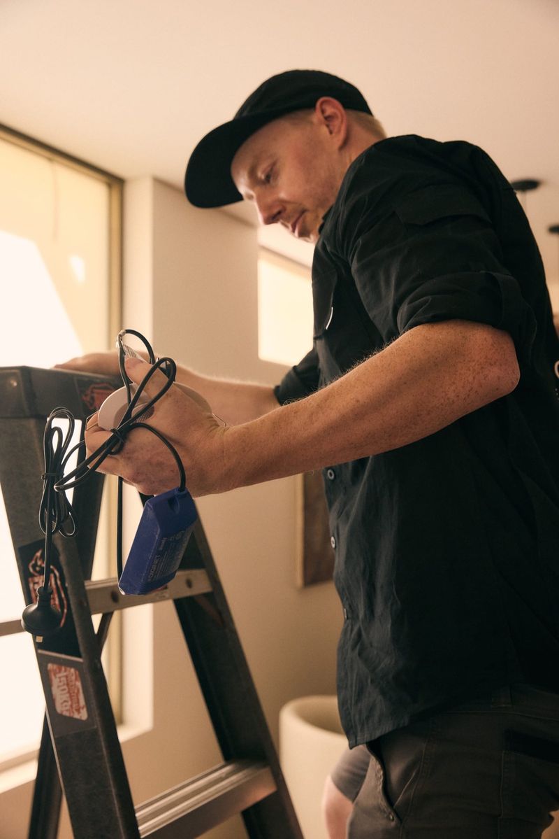 Electrician connecting wiring for a recessed downlight fitting during a home lighting upgrade
