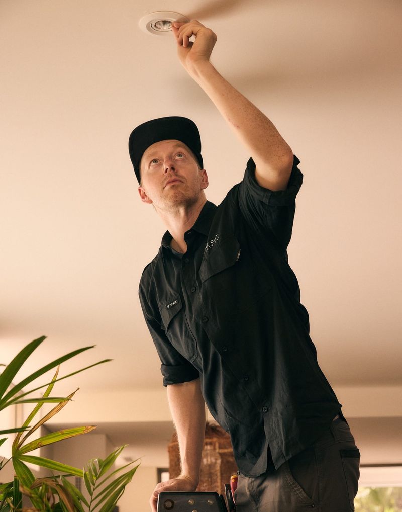 Close-up of an electrician fitting a recessed downlight — residential lighting upgrade Hobart